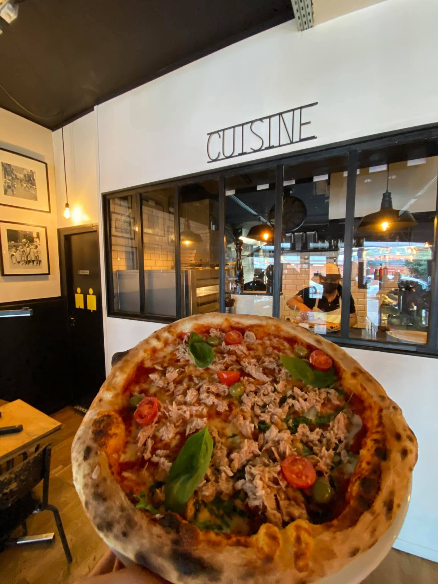 Pizza napolitaine sortie du four devant la cuisine